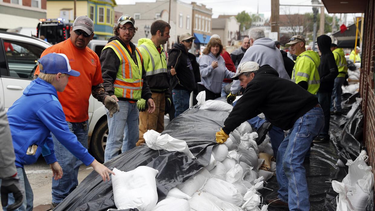 Los vecinos de Eureka, Missouri, recogen sacos de arenas para protegerse...