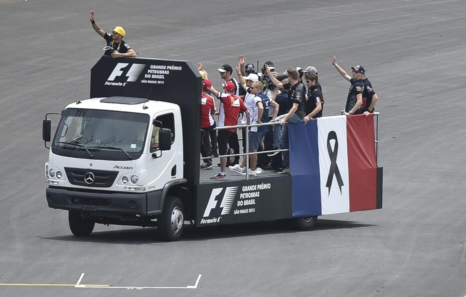 Corredores de Formula 1 desfilan a bordo de un camión con una bandera fr...