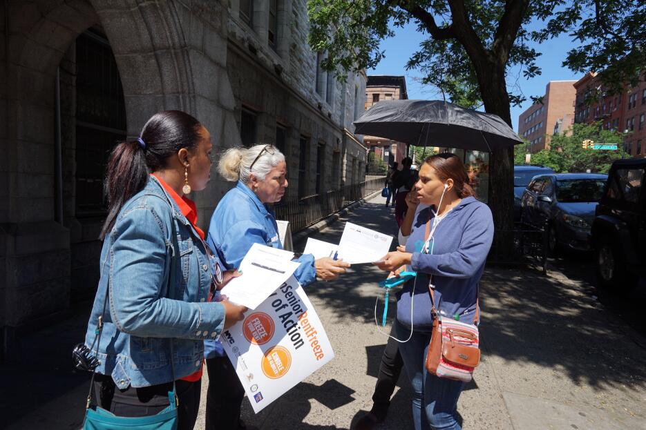 Miembros de "Freeze Your Rent" explican el programa a la comunidad.