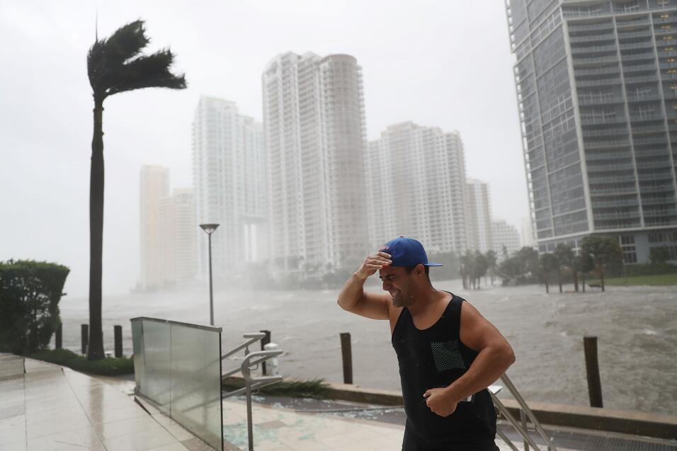 Un residente del centro de Miami lucha contra la fuerza de Irma, junto a...