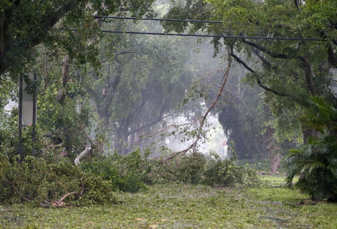 Debris fills the tree-lined streets of a residential area, Sunday, Sept....