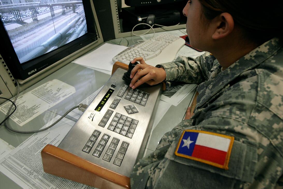 Vigilando la línea. Una miembro de la Guardia Nacional de Texas controla...